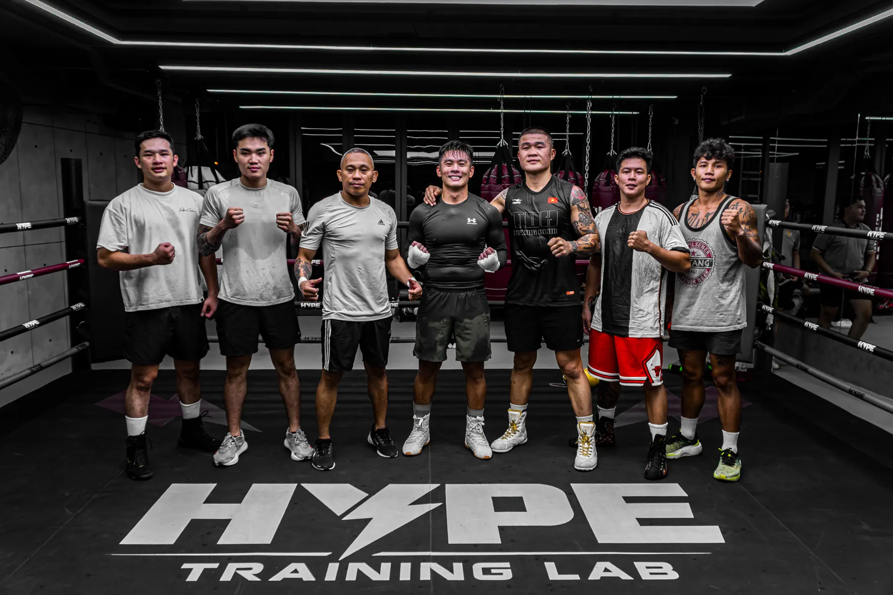 Đội ngũ Coach HYPE đứng trên sàn tập có logo HYPE