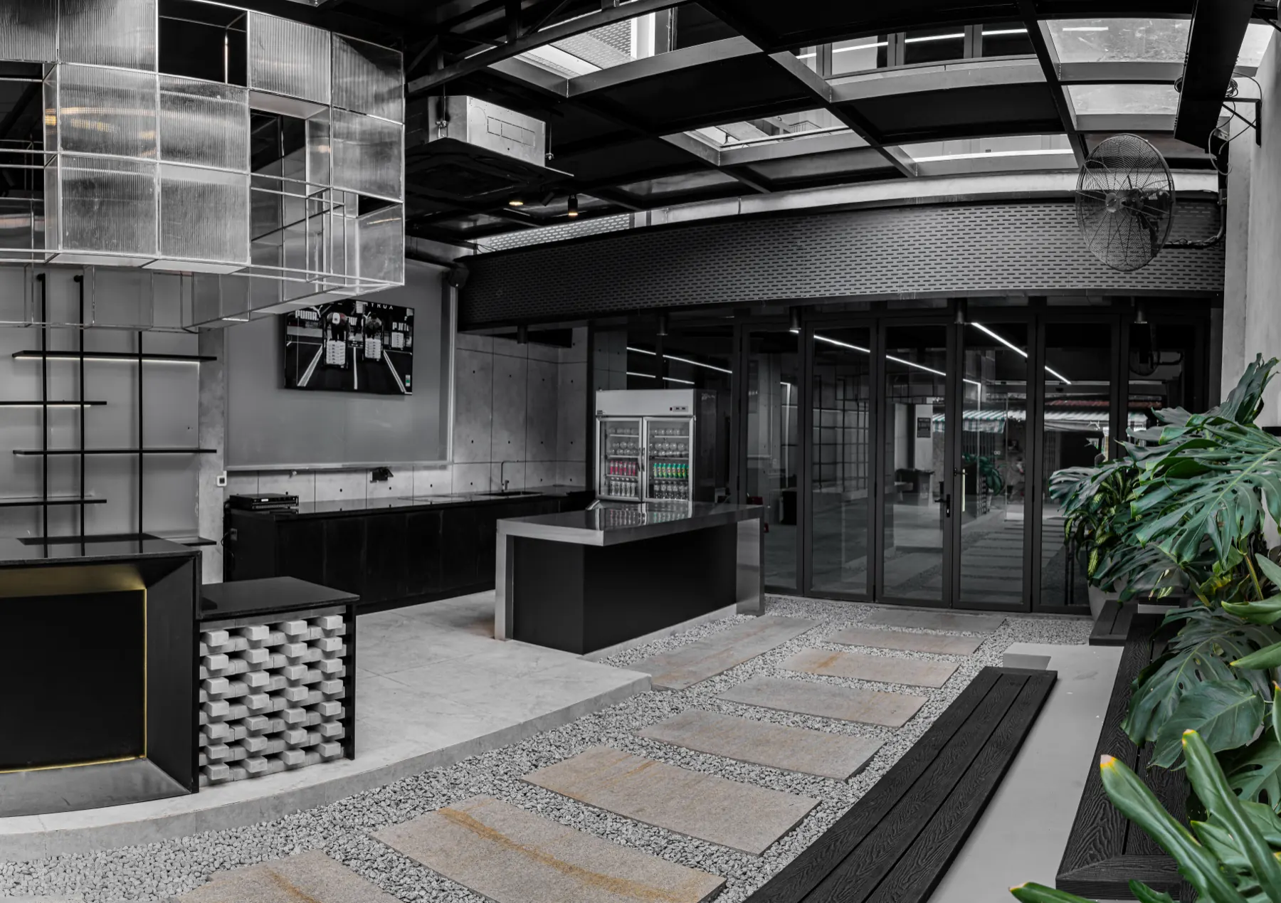 Khu Lounge tại HYPE — quầy lễ tân, kệ kim loại và cây xanh